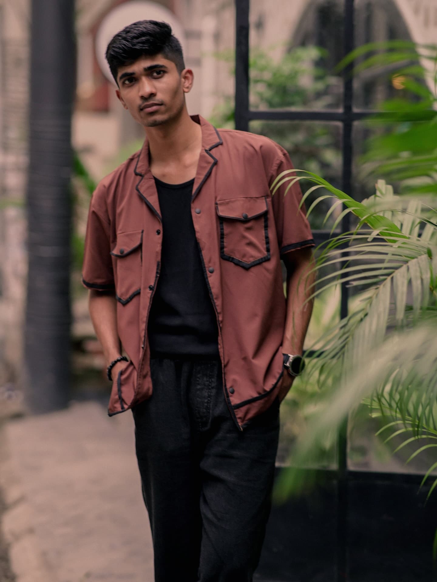 Rust camp-collar shirt with contrast pockets over a black tee